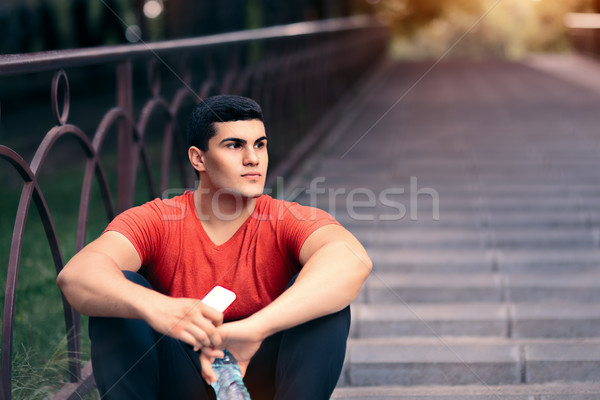 Fit Man Resting with Water Bottle and Phone Stock photo © NicoletaIonescu