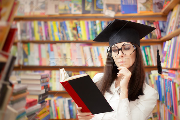 Stock photo: Curious School Student Reading a Book in a Library