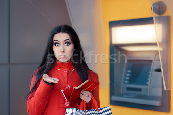 Stock photo: Funny Shopping Woman Holding a Penny in front of an ATM