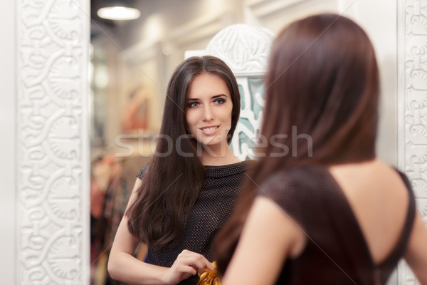 Beautiful Girl Looking in the Mirror and Trying on an Elegant Dress Stock photo © NicoletaIonescu