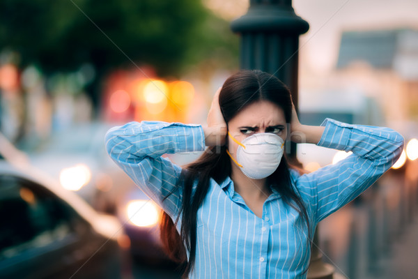 Girl With Mask Covering her Ears Because of Noise Pollution Stock photo © NicoletaIonescu