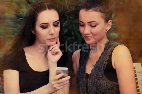Young Women Looking at Smart Phone Screen  Stock photo © NicoletaIonescu
