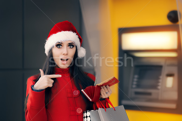 Christmas Woman Checking her Wallet in Front of a Bank ATM Stock photo © NicoletaIonescu