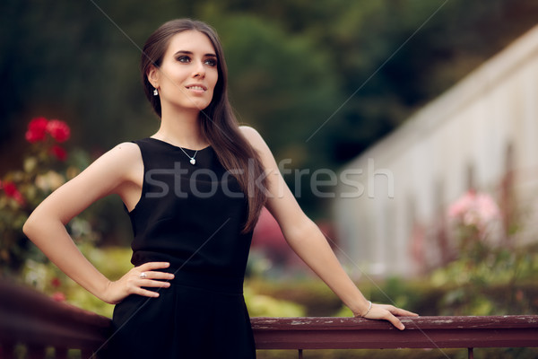 Elegante vrouw zwarte jurk permanente patio Stockfoto © NicoletaIonescu