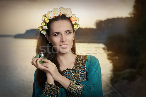 Young Woman Holding Perfume Bottle in Sunlight   Stock photo © NicoletaIonescu