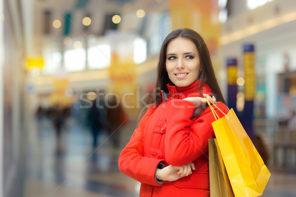 Happy Girl in a Red Coat Shopping in a Mall Stock photo © NicoletaIonescu