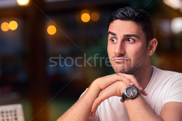 Surprised Young Man Sitting in a Restaurant Stock photo © NicoletaIonescu