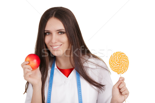 Nutritionist Holding an Apple and a Big Candy  Stock photo © NicoletaIonescu