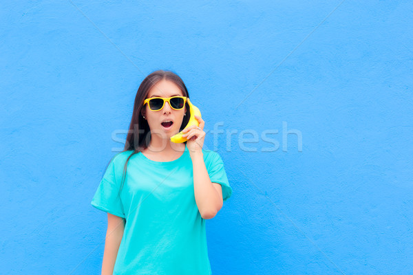 Funny Girl with Sunglasses and Banana Phone on Blue Background Stock photo © NicoletaIonescu