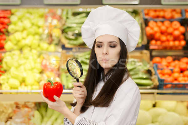 Concerned  Lady Chef Inspecting Vegetables with Magnifying Glass Stock photo © NicoletaIonescu