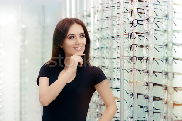 Stock photo: Woman Choosing Eyeglasses Frames in Optical Store