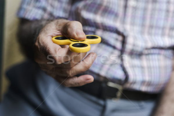 old man playing with a fidget spinner Stock photo © nito