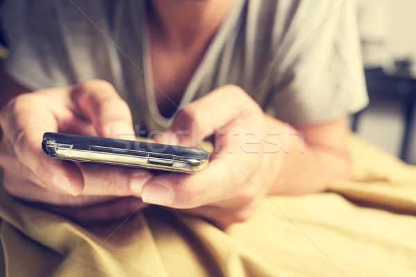 Jonge man smartphone bed jonge kaukasisch Stockfoto © nito