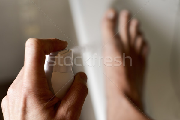 young man applying deodorant to his feet Stock photo © nito