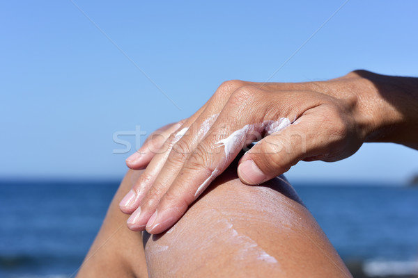 man applying sunscreen to his thigh Stock photo © nito