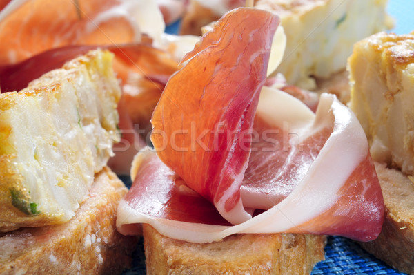 spanish pinchos: spanish tortilla and serrano ham served on brea Stock photo © nito