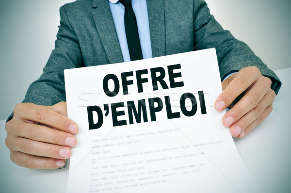 Stock photo: man with a document with the text offres d'emploi, jobs in frenc