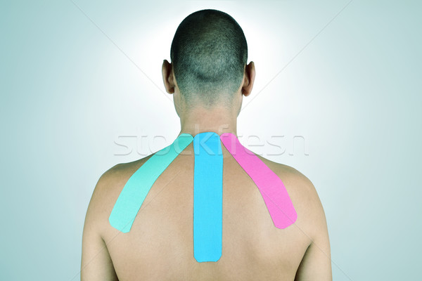 young man with some strips of elastic therapeutic tape in his ba Stock photo © nito