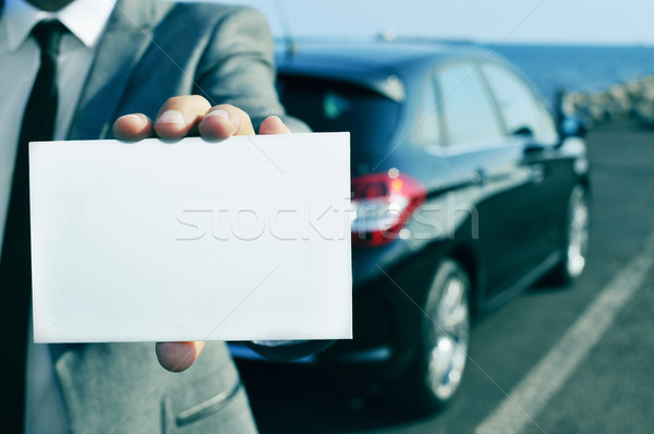 man in suit holding a blank signboard with a car in the backgrou Stock photo © nito