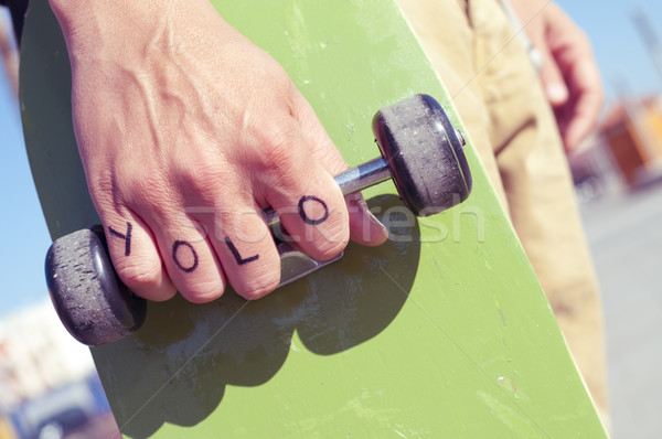 Stock photo: young man with the word yolo, for you only live once, tattooed 