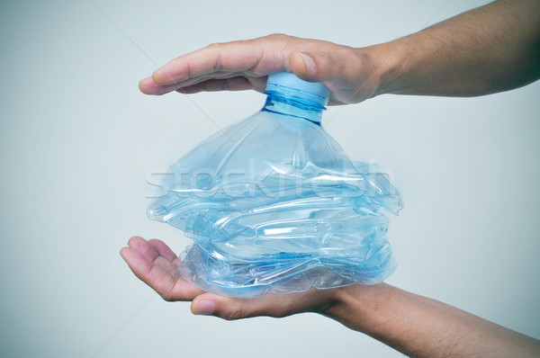 young man smashing a plastic bottle with his hands Stock photo © nito