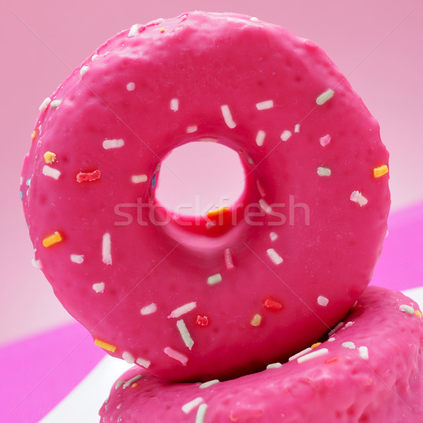 Stock photo: donuts coated with a pink frosting and sprinkles of different co