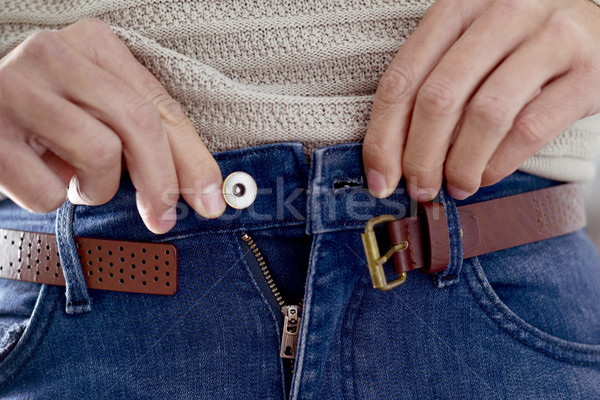 young man trying to fasten his trousers Stock photo © nito