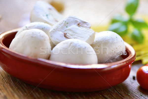 fresh mushrooms in an earthenware bowl on a wooden table Stock photo © nito