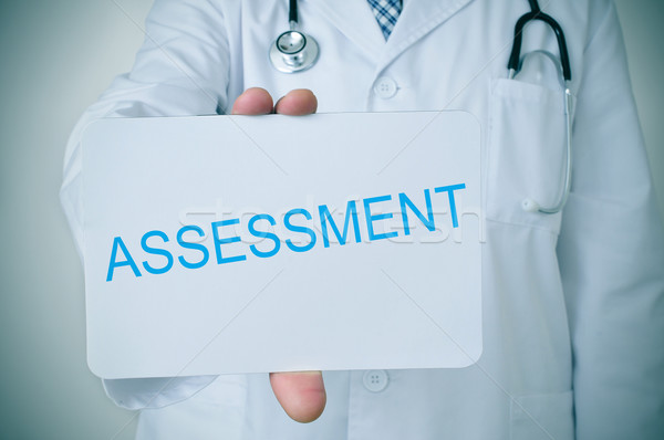 doctor showing a signboard with the word assessment Stock photo © nito
