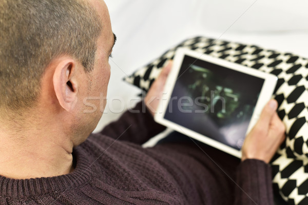 Stock photo: young man watching a movie or a series in his tablet