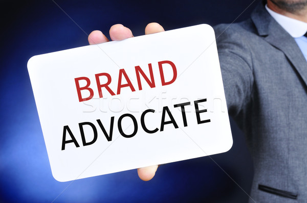 businessman shows a signboard with the text brand advocate Stock photo © nito