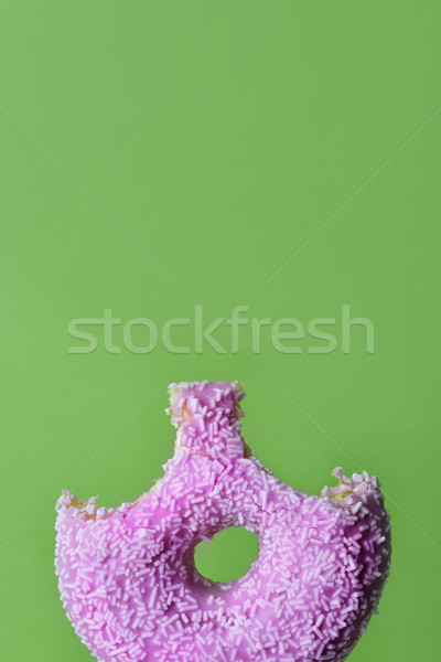 nibbled pink donut on a green background Stock photo © nito
