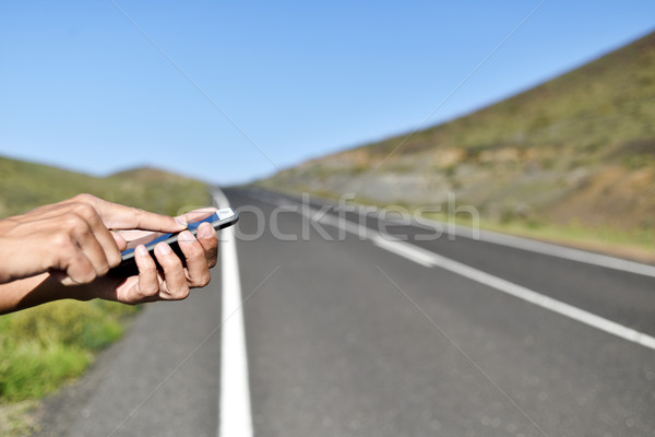 man using a smartphone next to the road Stock photo © nito