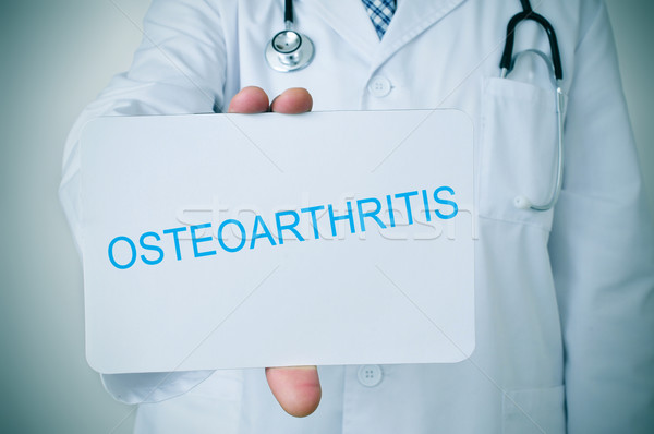 doctor with a signboard with the text osteoarthritis  Stock photo © nito
