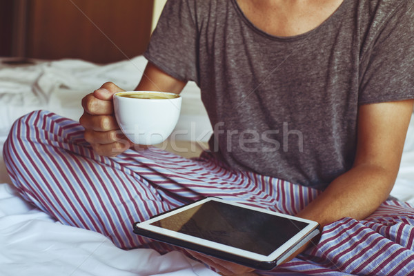 young man in pajamas using a tablet computer Stock photo © nito