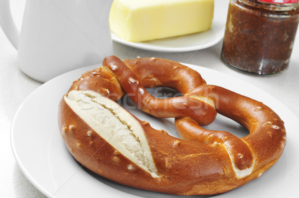 a laugenbrezel, a german pretzel, on a set table for breakfast Stock photo © nito