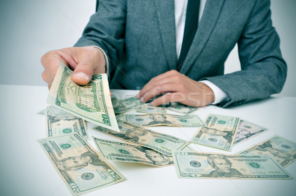 man in suit giving dollar bills Stock photo © nito
