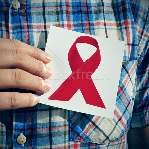 young man with a picture of a red ribbon for the fight against A Stock photo © nito
