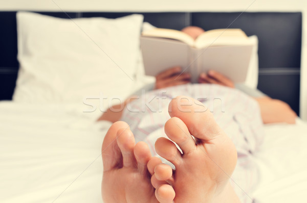 young man reading a book in bed Stock photo © nito
