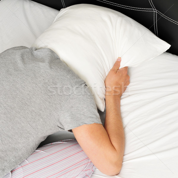 Fiatalember arc lefelé ágy fej párna Stock fotó © nito