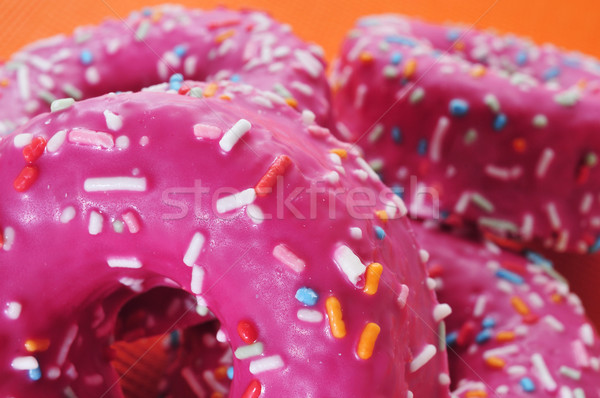 donuts coated with a pink frosting and sprinkles of different co Stock photo © nito