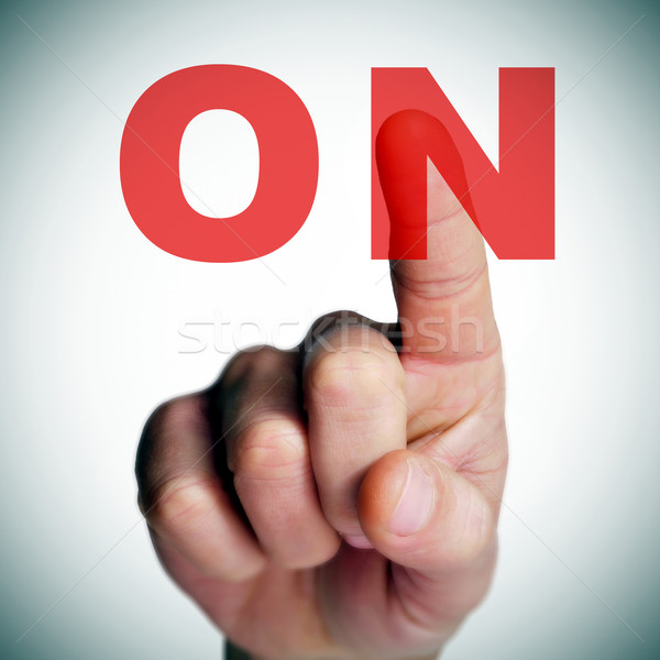 a man finger clicking an on button on a transparent screen Stock photo © nito