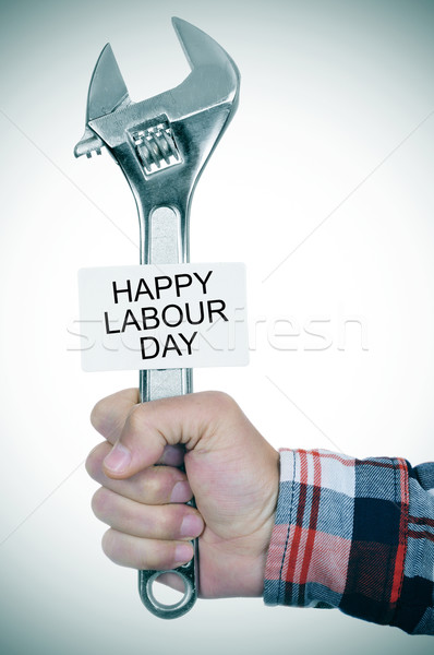 man with adjustable wrench and signboard with text happy labour  Stock photo © nito