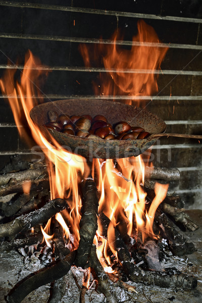 Stock photo: chestnuts roasting in the flames of a log fire