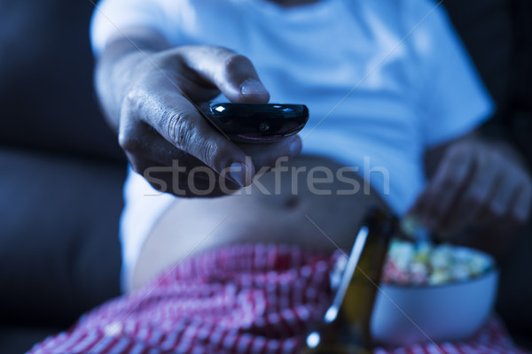Stock photo: man drinking beer and eating popcorn