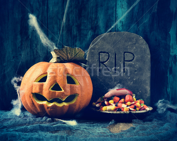 carved pumpkin, gravestone and Halloween candies Stock photo © nito