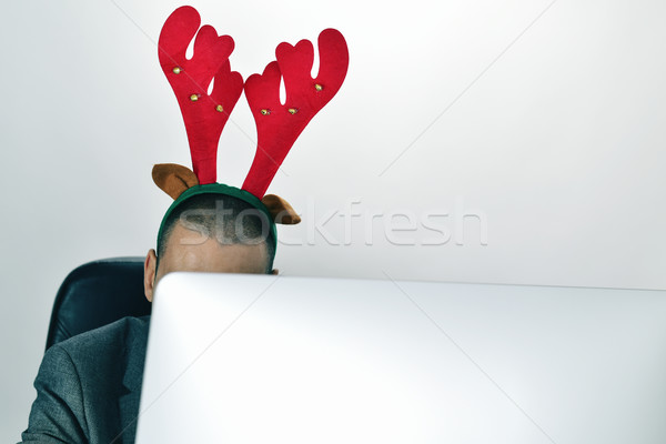 businessman with a reindeer antlers headband in his office Stock photo © nito