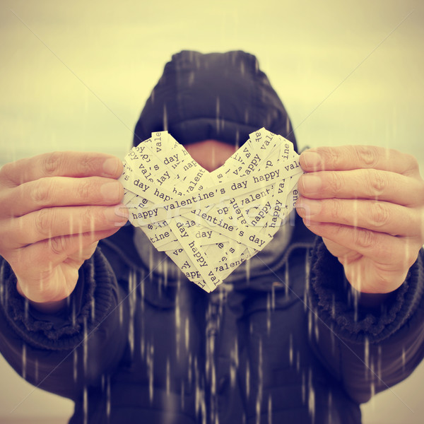 young man swhoing a heart under the rain, with a filter effect Stock photo © nito