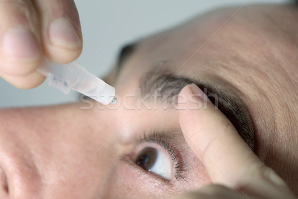 man applying eye drops to his eyes Stock photo © nito