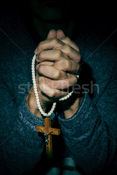 Stock photo: young man with a crucifix in his hands